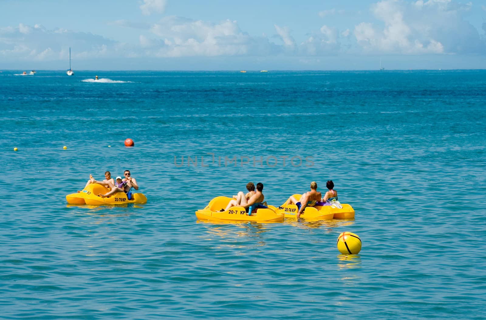 people in a yellow pedal boat  close to beach