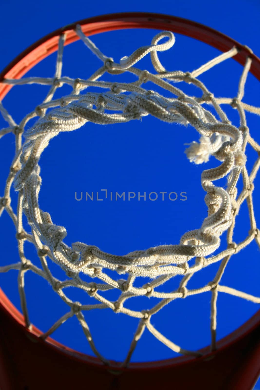 Basketball net over clear blue sky.
