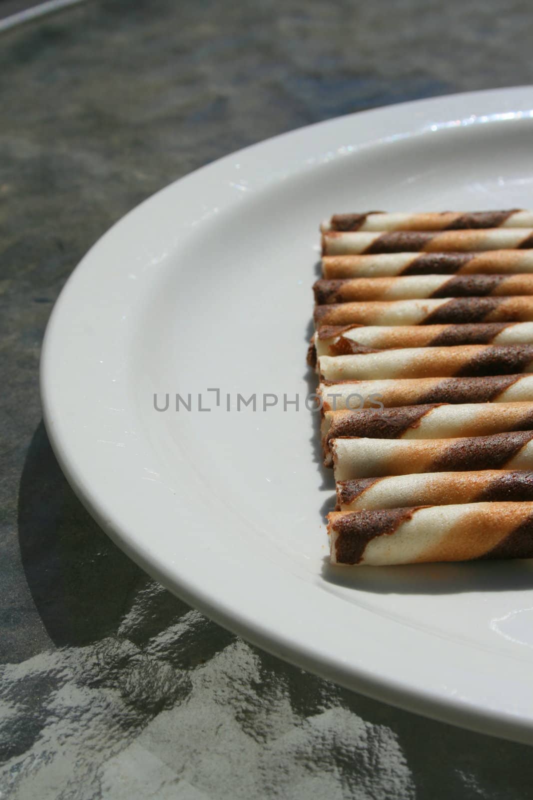 Close up of chocolate cookie sticks on a plate.
