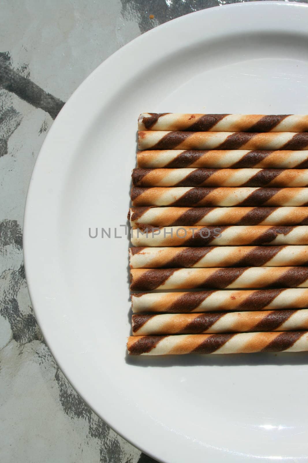 Close up of chocolate cookie sticks on a plate.
