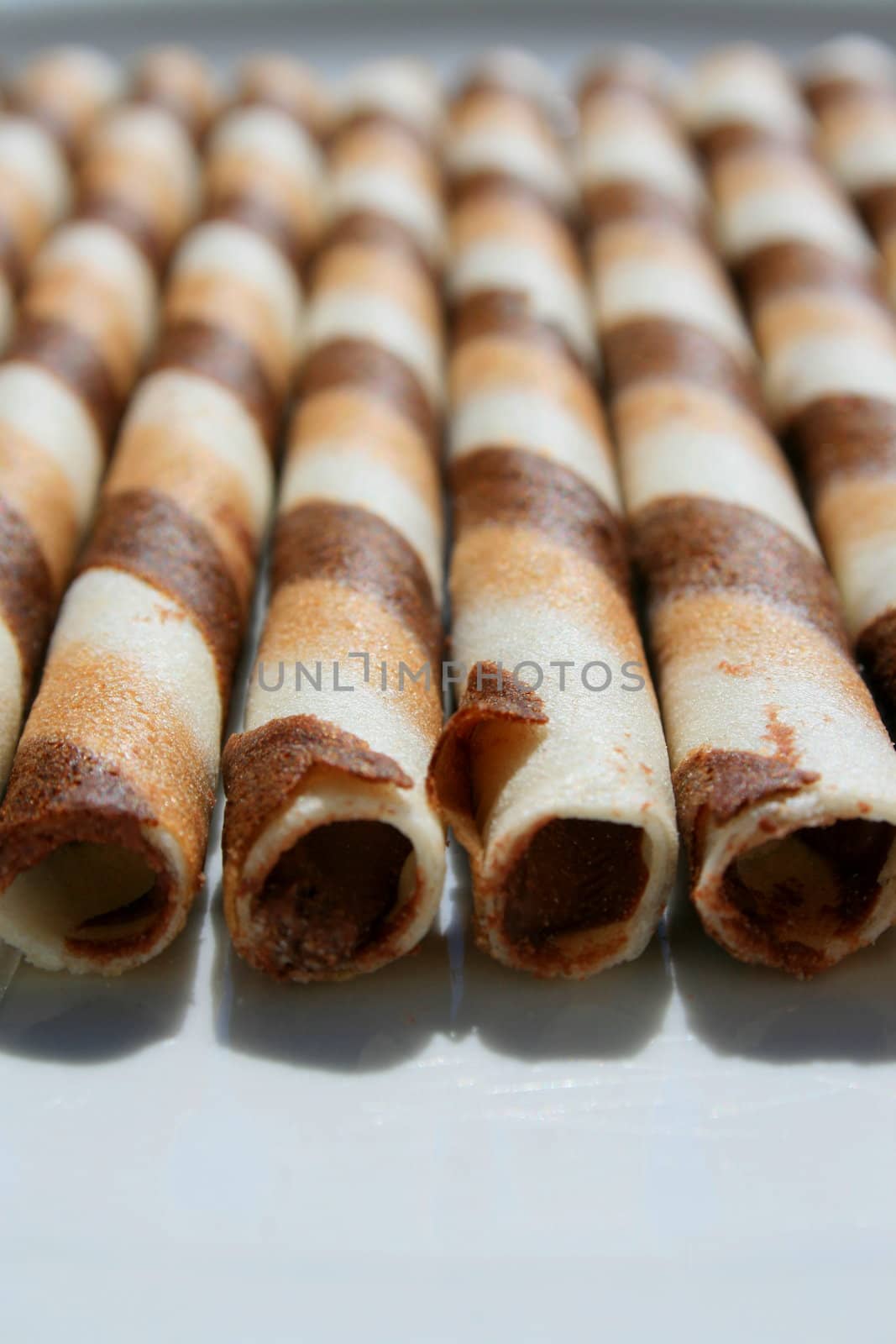Close up of chocolate cookie sticks on a plate.
