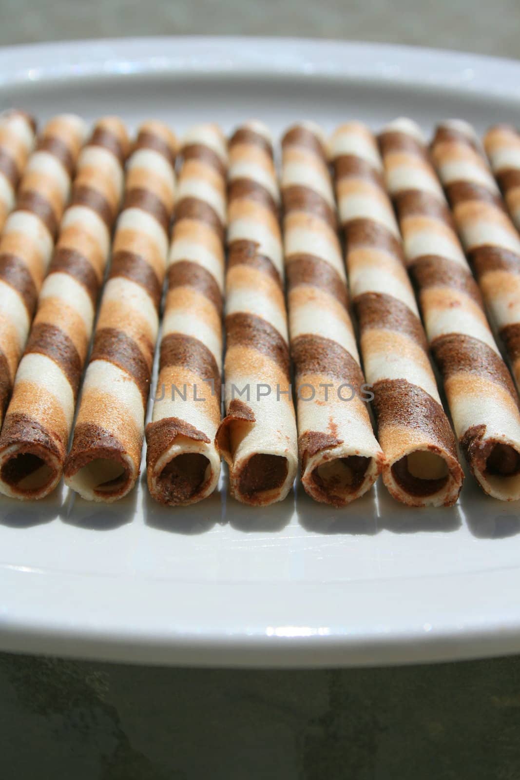 Close up of chocolate cookie sticks on a plate.
