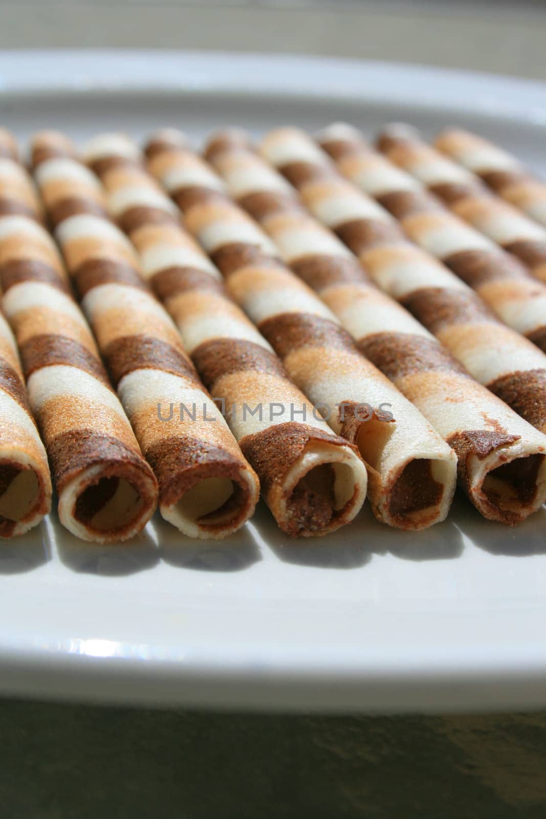 Close up of chocolate cookie sticks on a plate.
