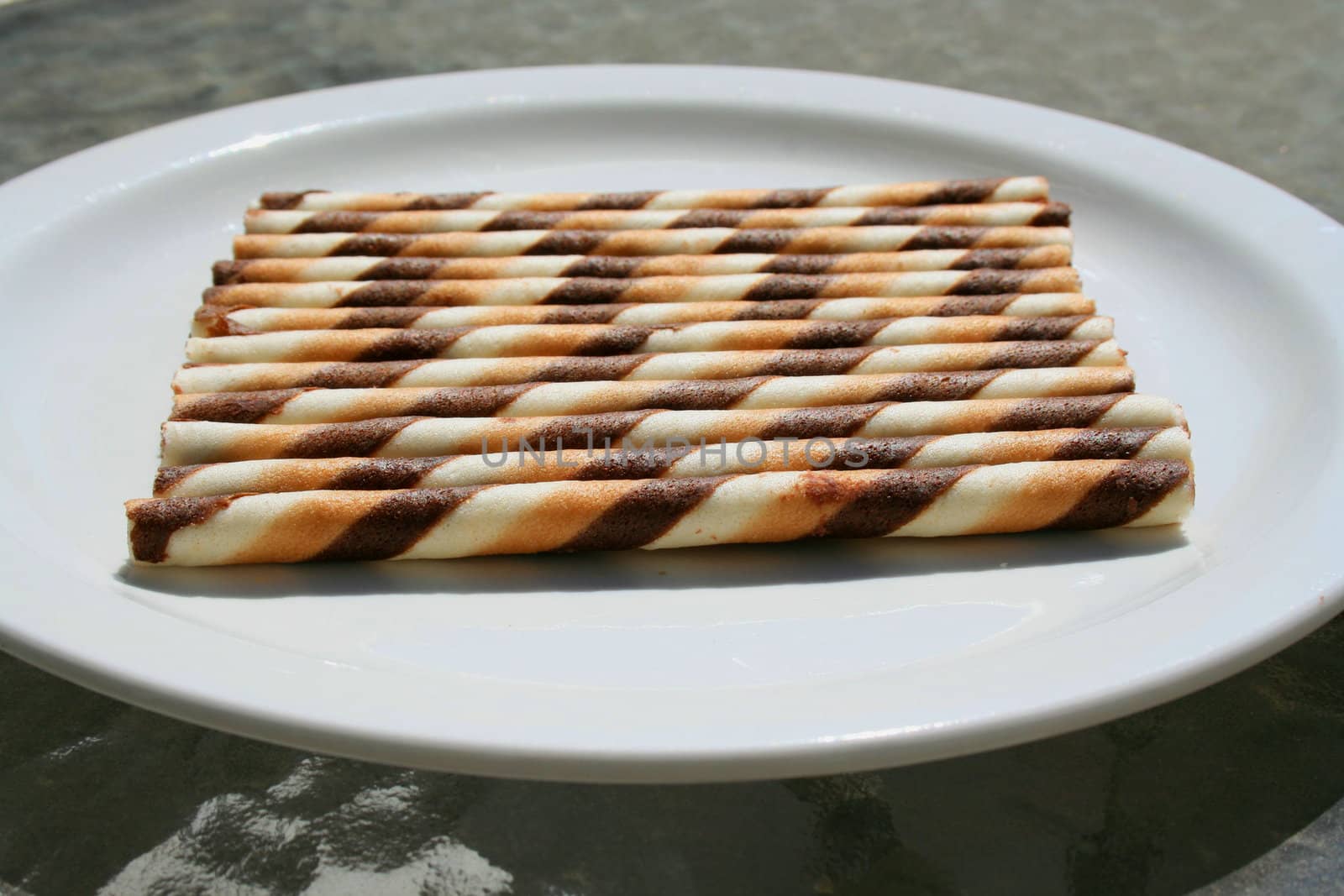 Close up of chocolate cookie sticks on a plate.
