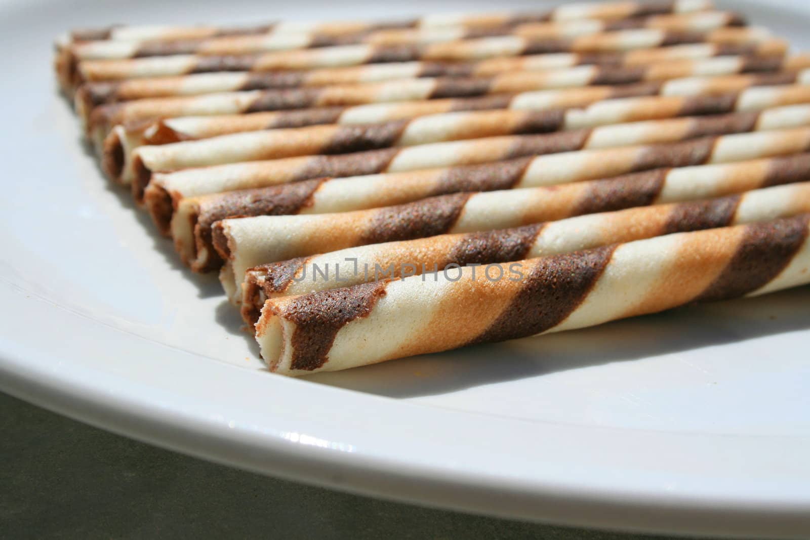 Close up of chocolate cookie sticks on a plate.
