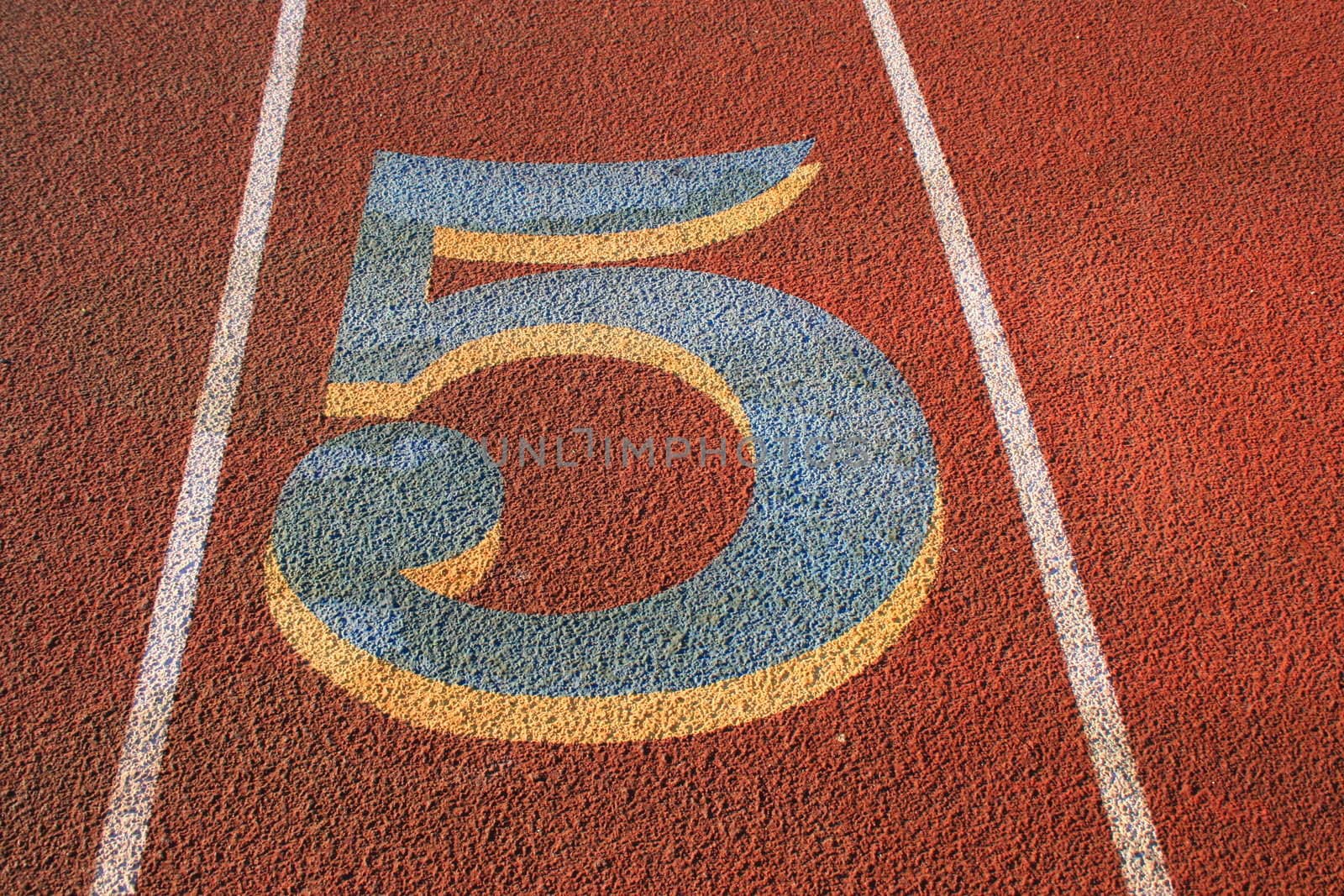 Close up of a number five on a running lane.
