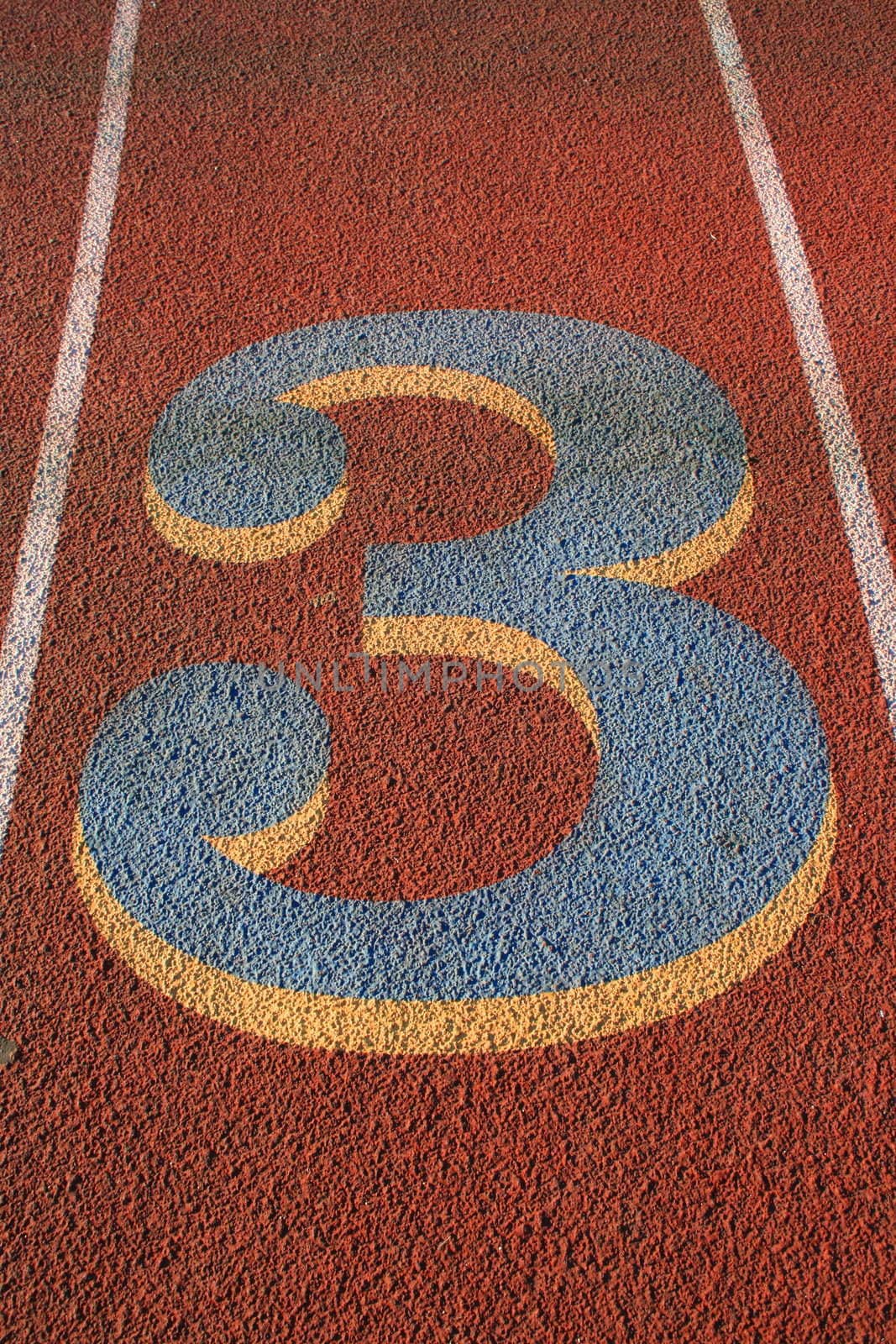 Close up of a number three on a running lane.
