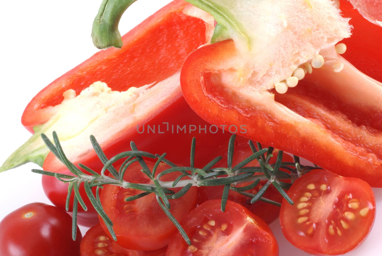 Red paprika cut open, surrounded by cherry tomatoes. 