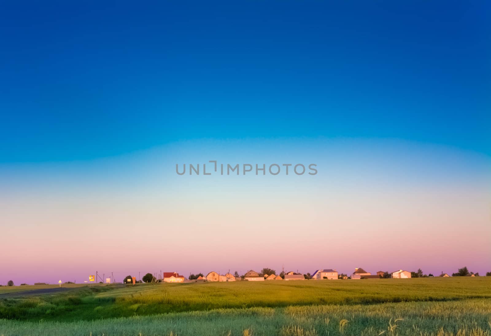 farm houses on the field at sunset