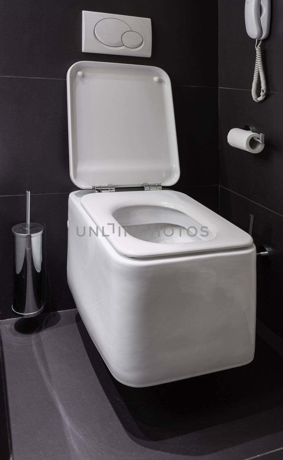 Details of modern square toilet wc in black tiled bathroom