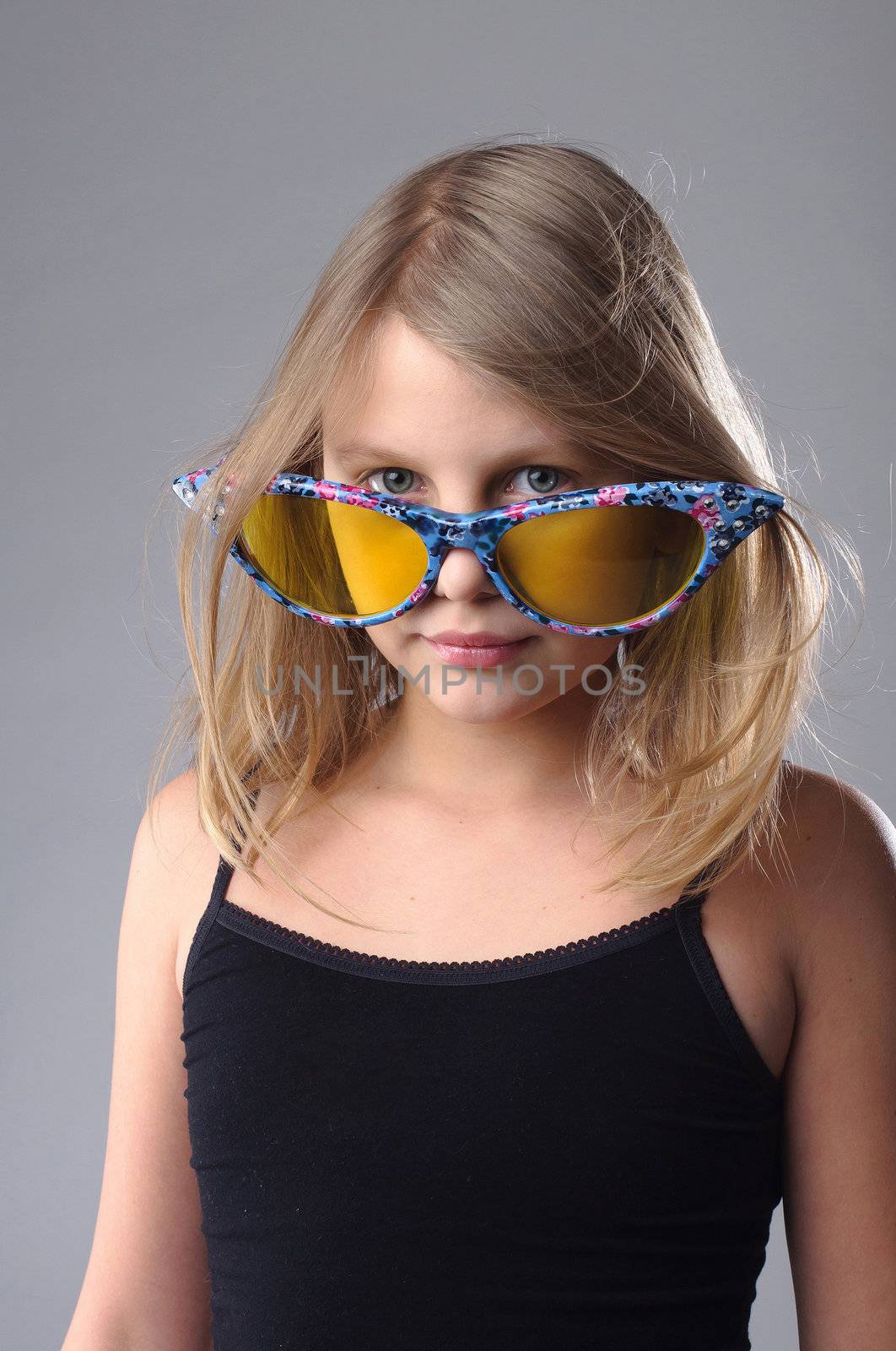 Little girl in funny big glasses in studio.