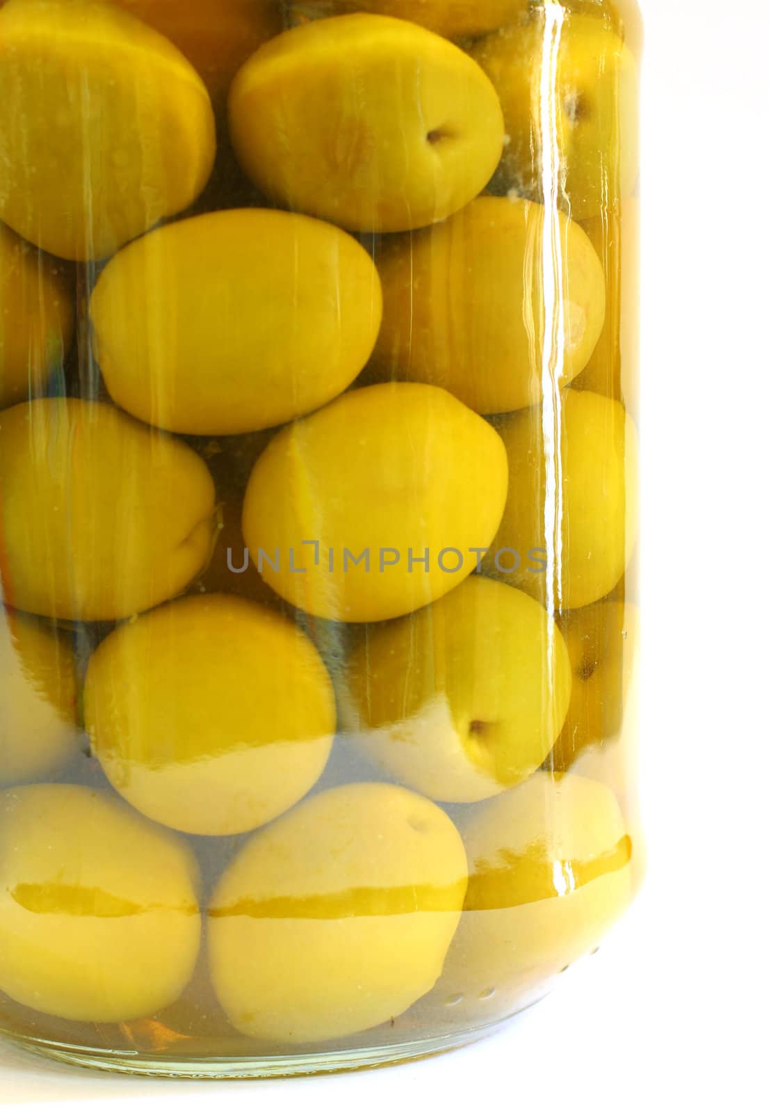 Close up a jar of stuffed green olives on white background