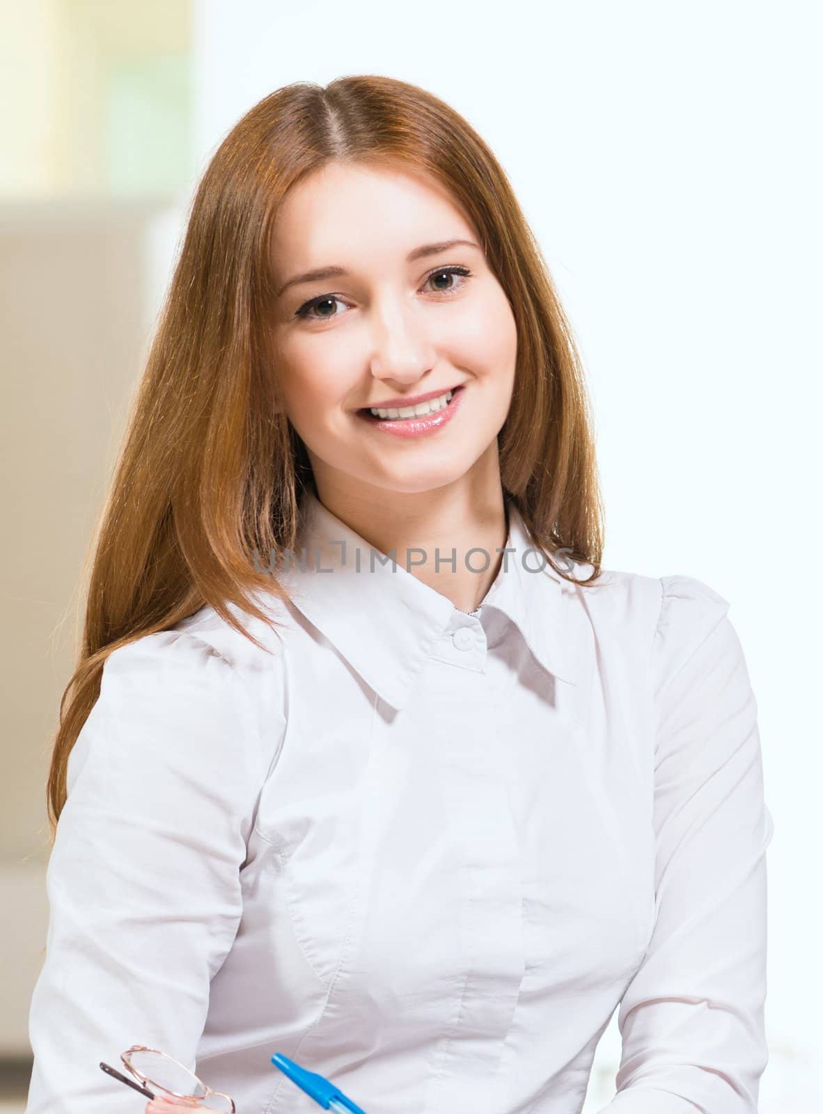 Portrait of an attractive woman sitting on the floor cross-legged and holds the tablet for notes