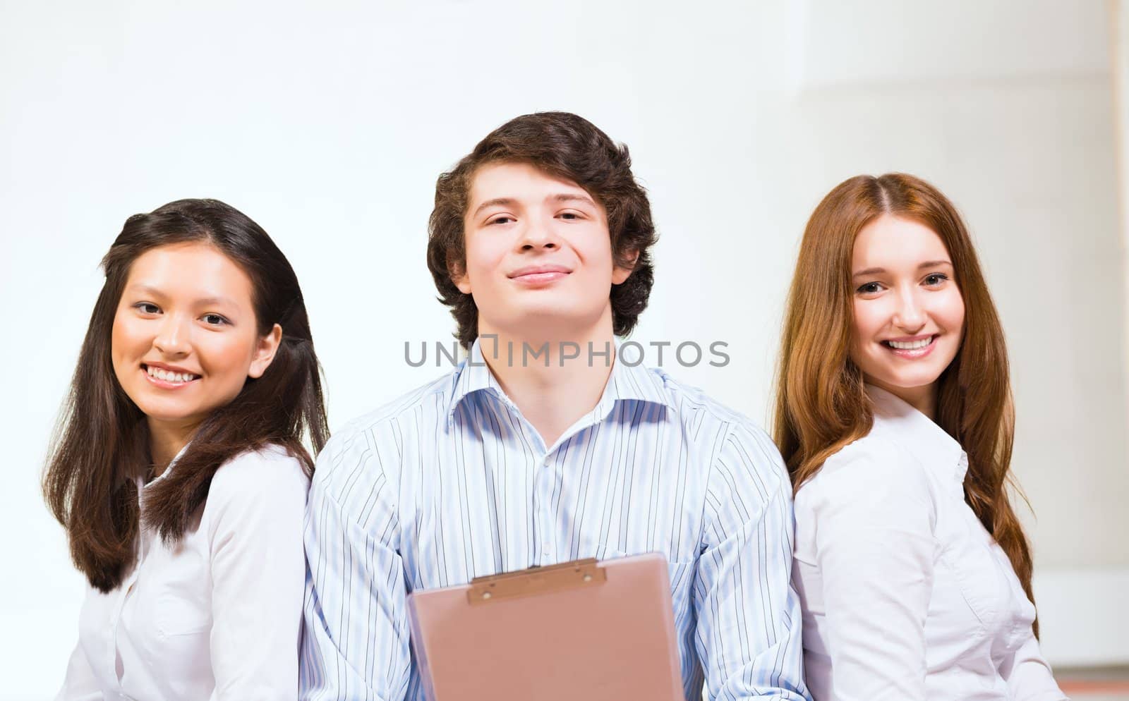 portrait of a group of young people sitting on the floor, man and two attractive women