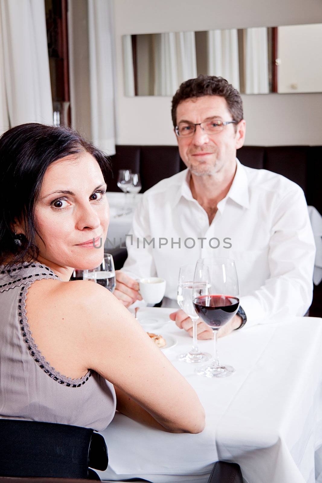 happy smiling couple in restaurant for dinner sitting talking drinking