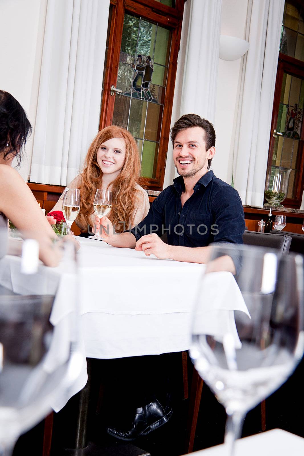 smiling happy people in restaurant drinking talking having fun 