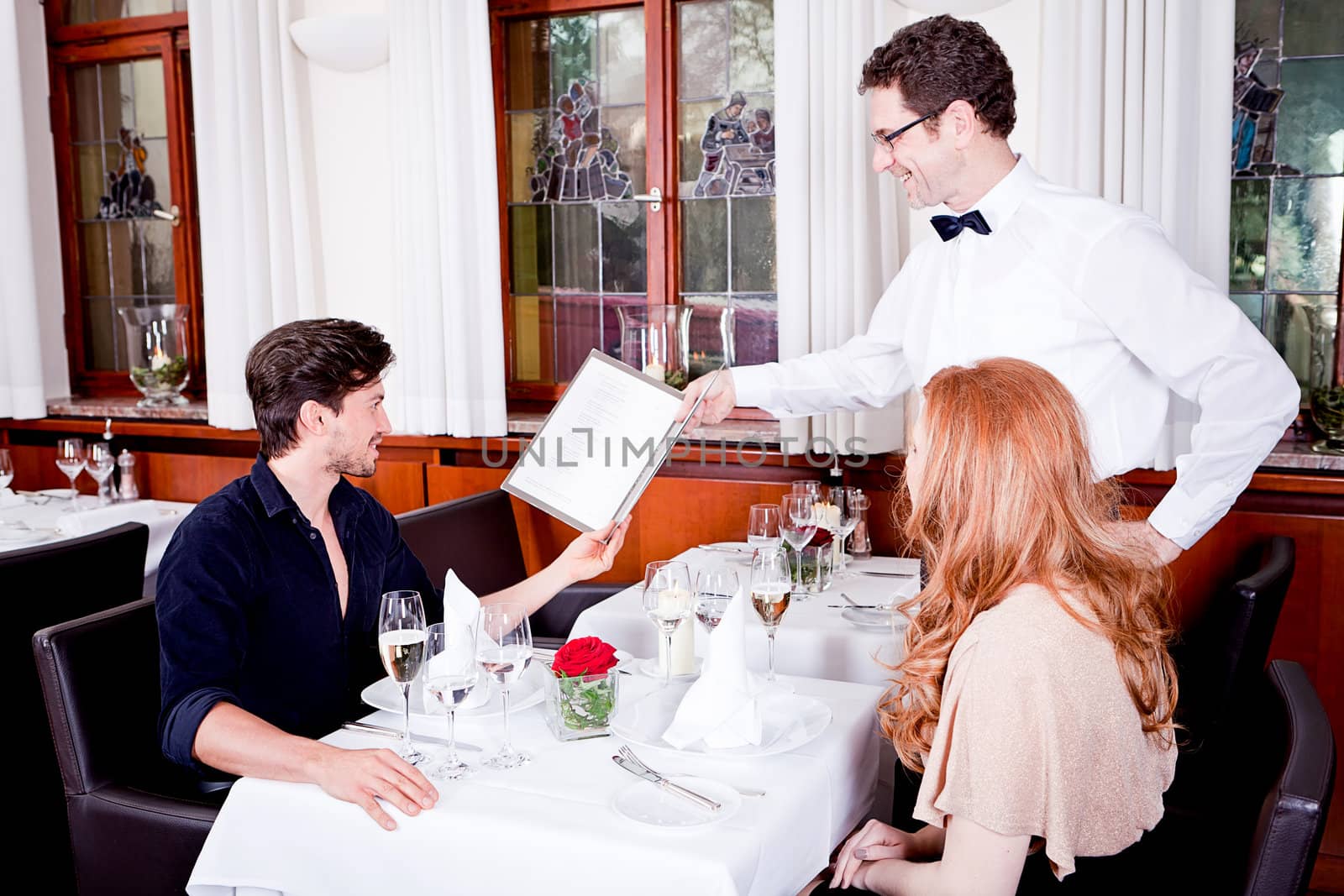 man and woman in restaurant waiter bring card and order food