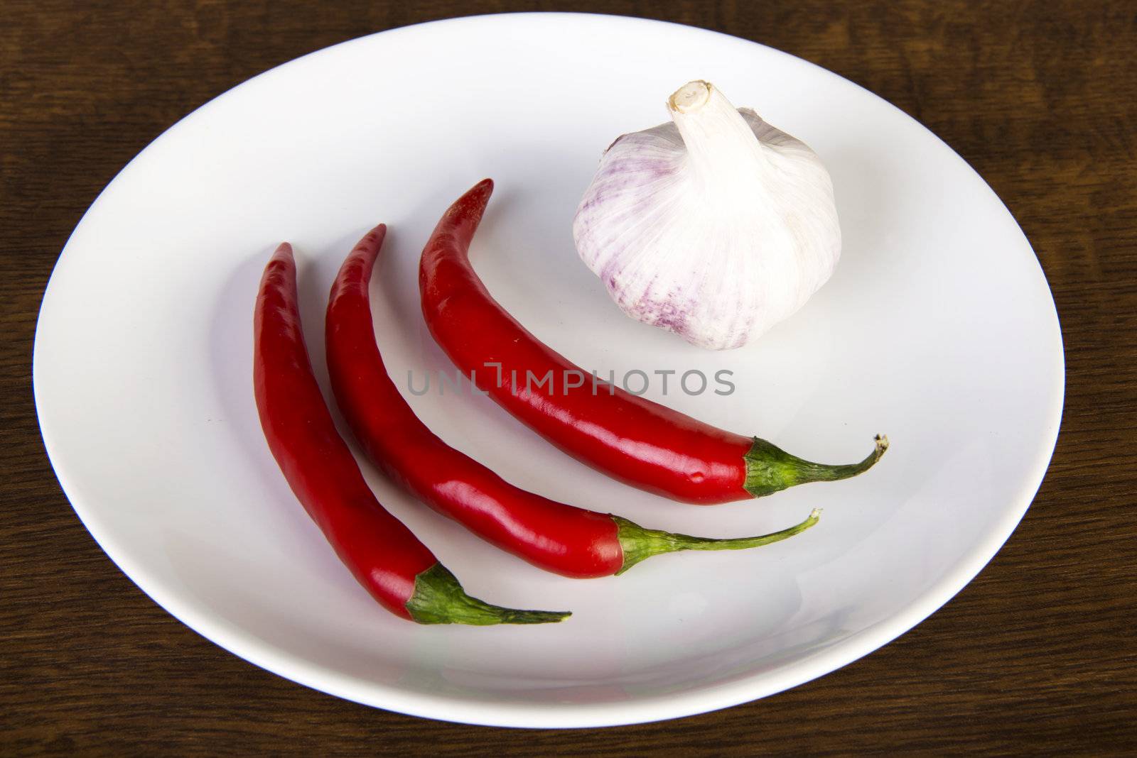 Red chili peppers and garlic on plate