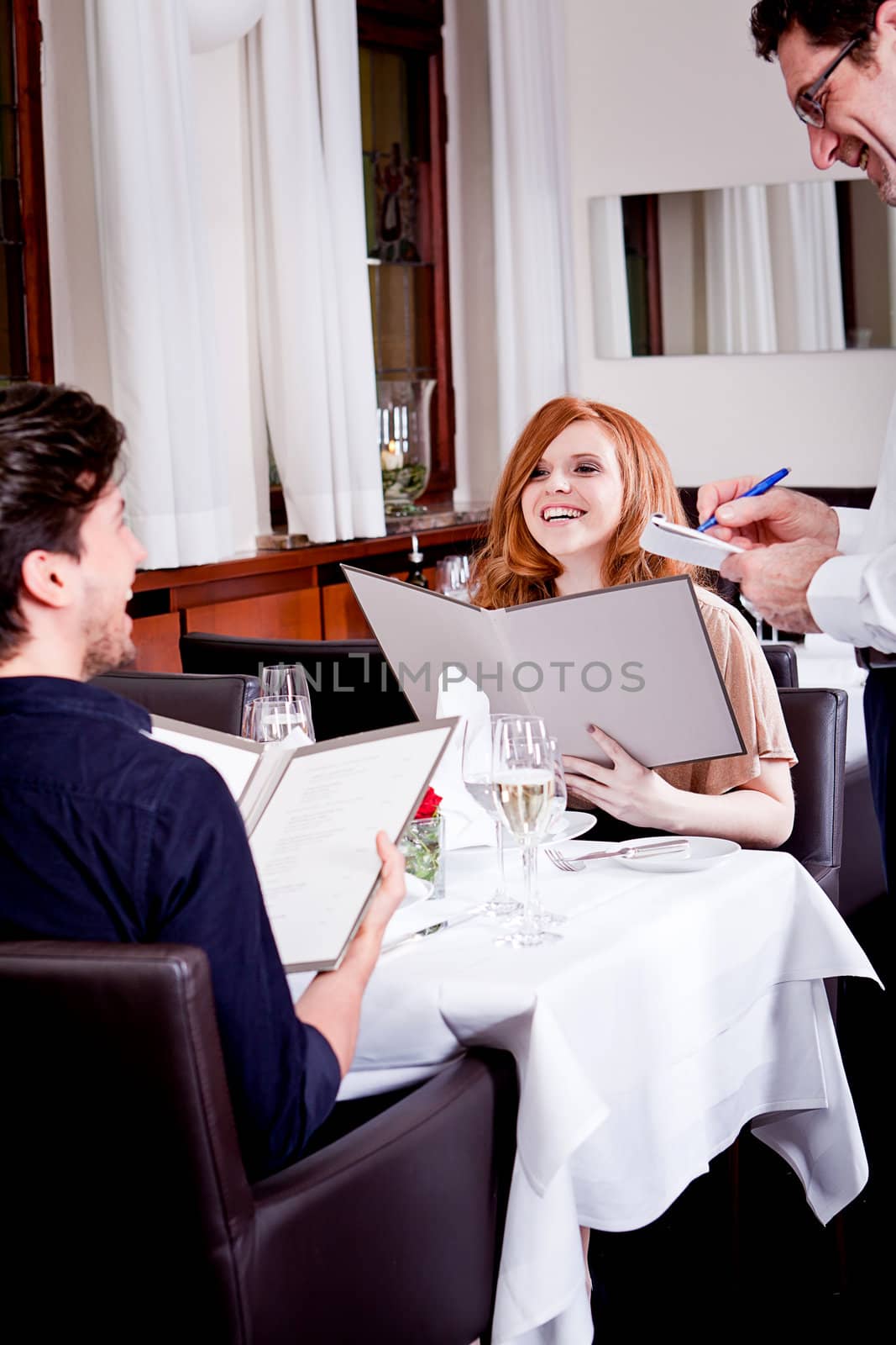 man and woman in restaurant waiter bring card and order food