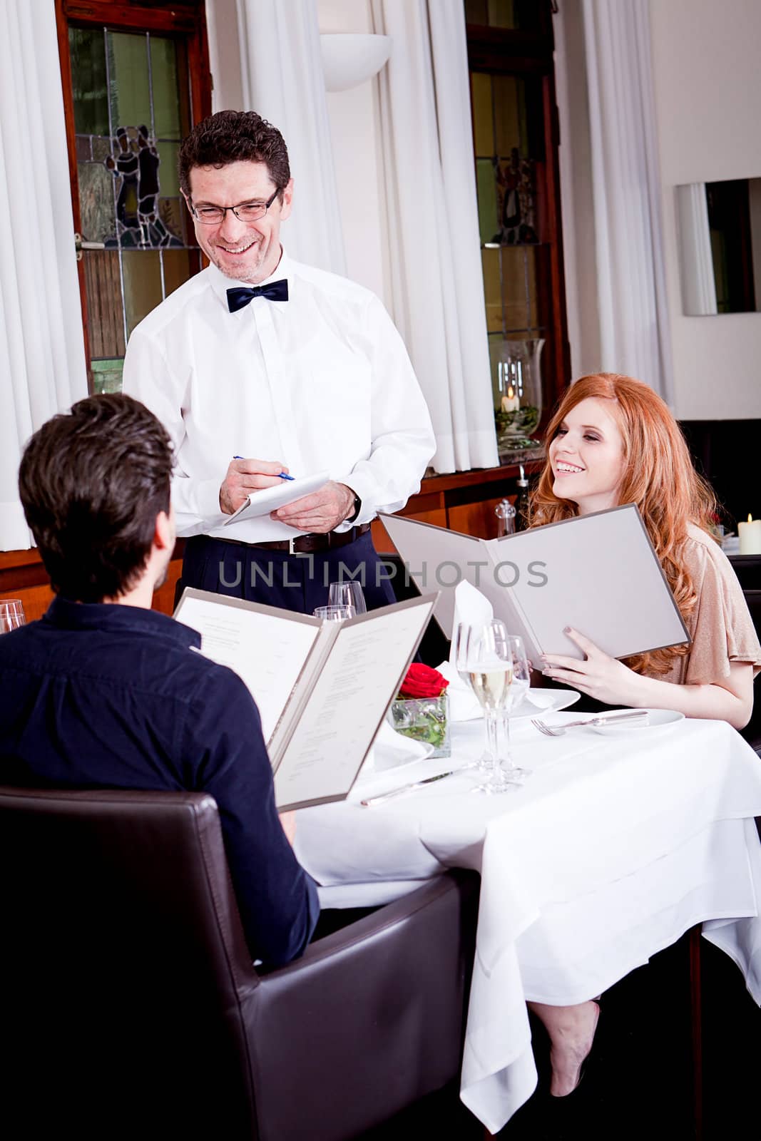 man and woman in restaurant waiter bring card and order food