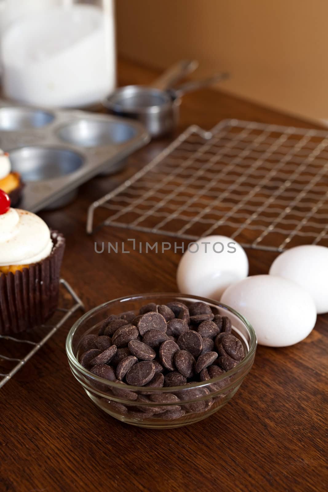 A bowl of bakers chocolate chips and other ingredients laid out on a countertop.