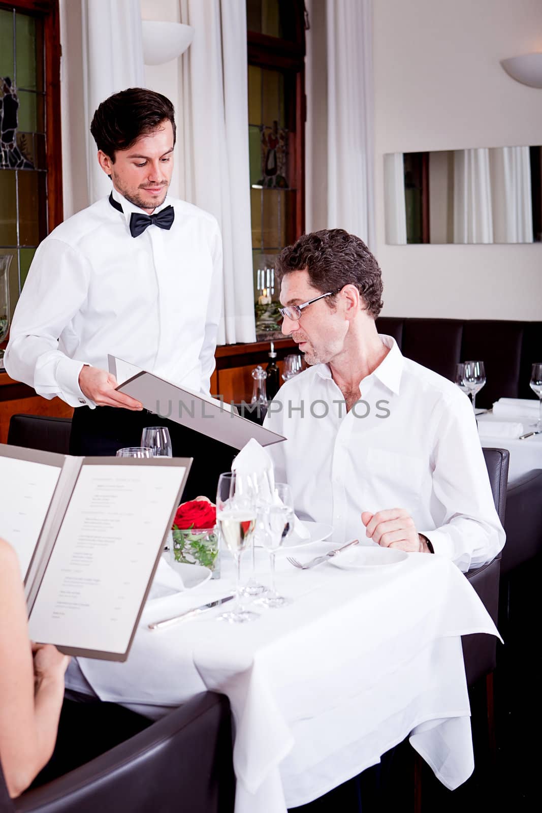 man and woman in restaurant waiter bring card and order food