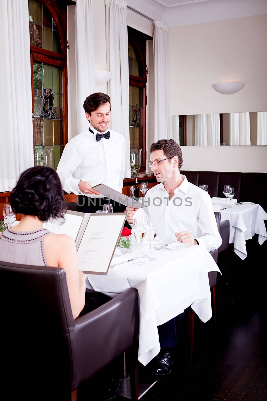 man and woman in restaurant waiter bring card and order food