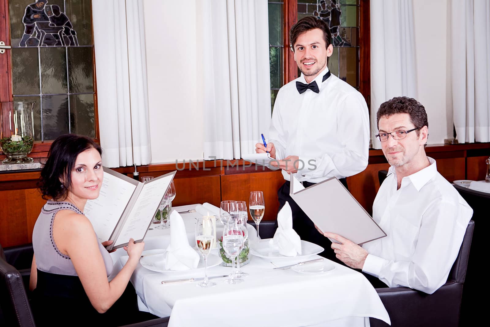 man and woman in restaurant waiter bring card and order food