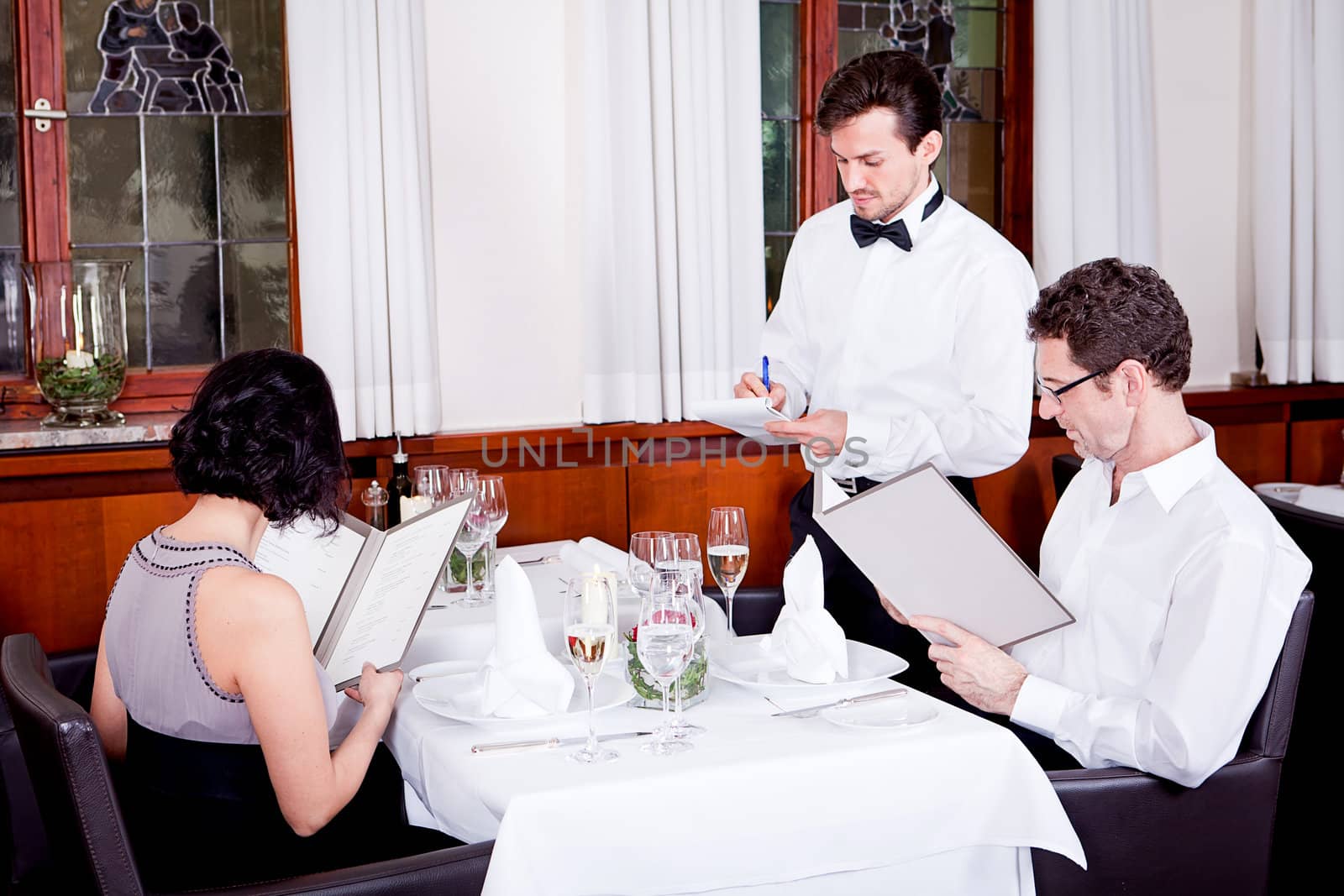 man and woman in restaurant waiter bring card and order food