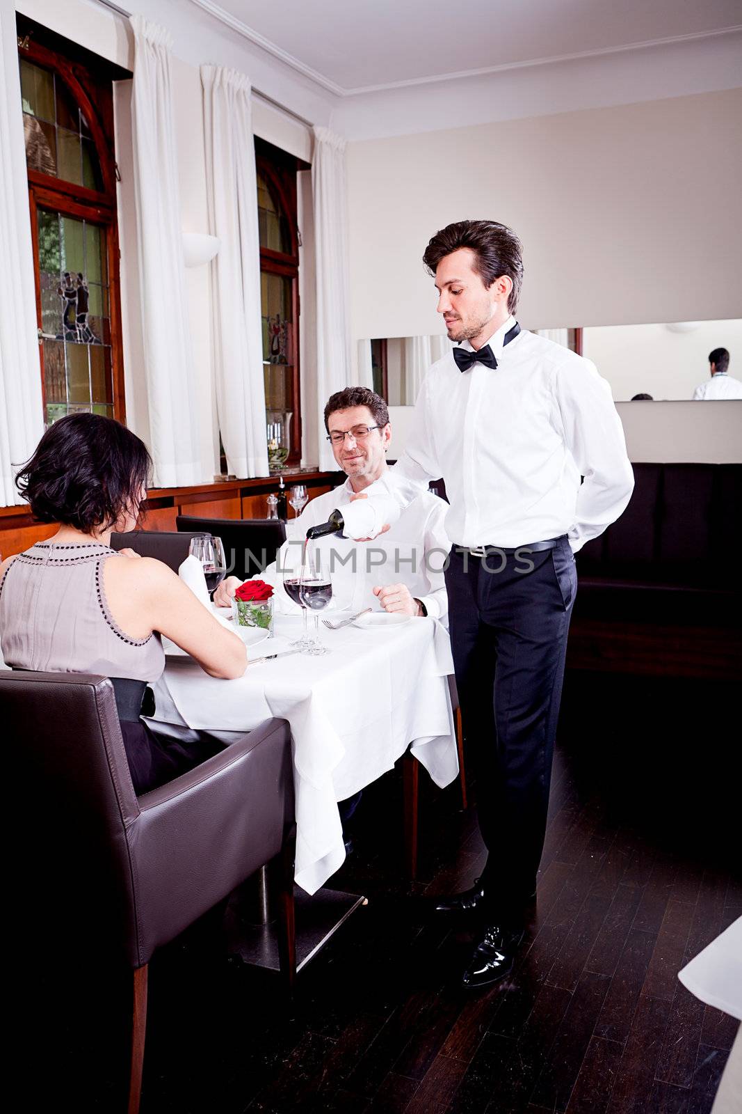 man and woman in restaurant for dinner drinking red wine and smiling