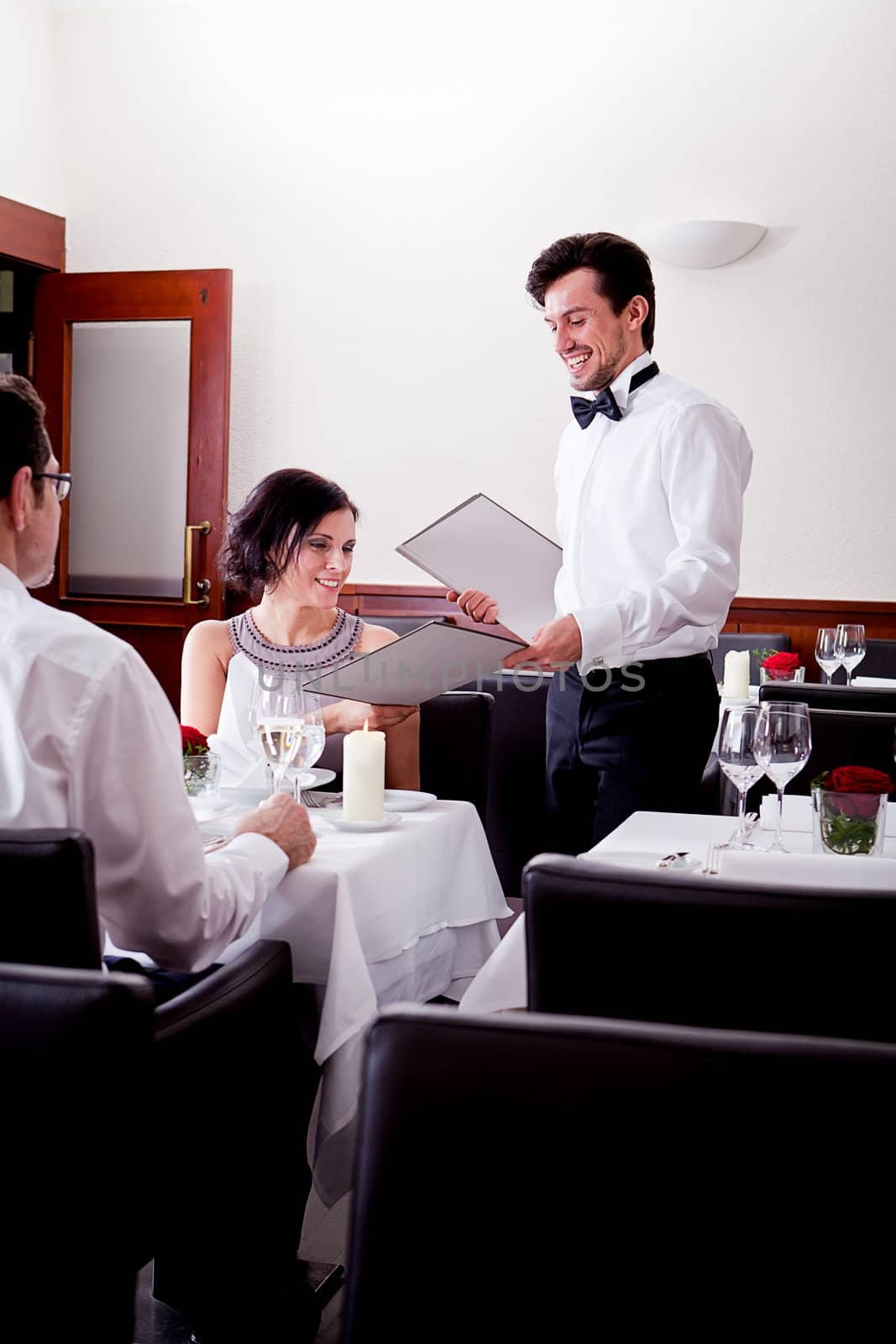 man and woman in restaurant for dinner by juniart