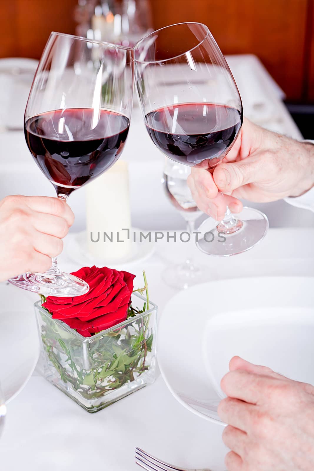 man and woman in restaurant for dinner drinking red wine and smiling