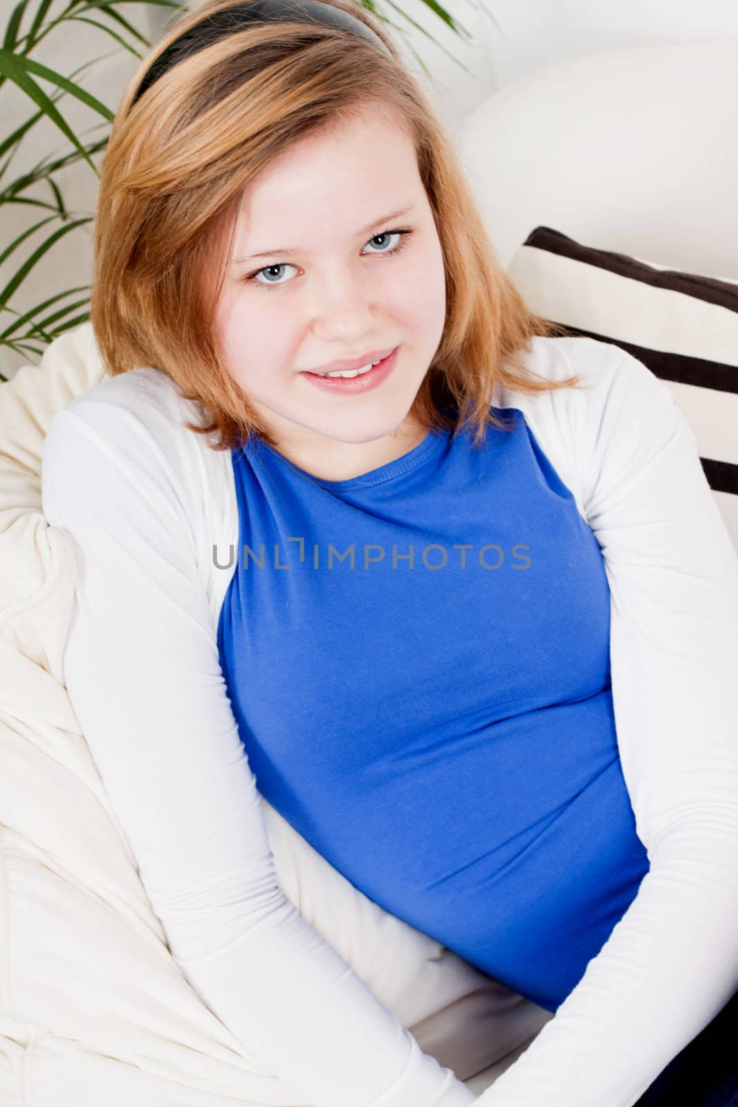 happy teenager girl smiling sitting on couch  by juniart