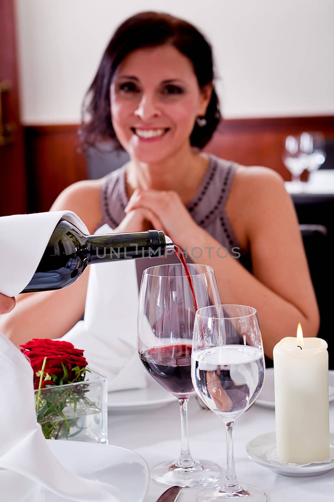 man and woman in restaurant for dinner drinking red wine and smiling