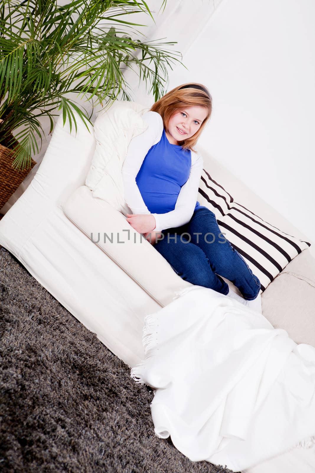 happy teenager girl smiling sitting on couch and relaxing lifestyle leisure