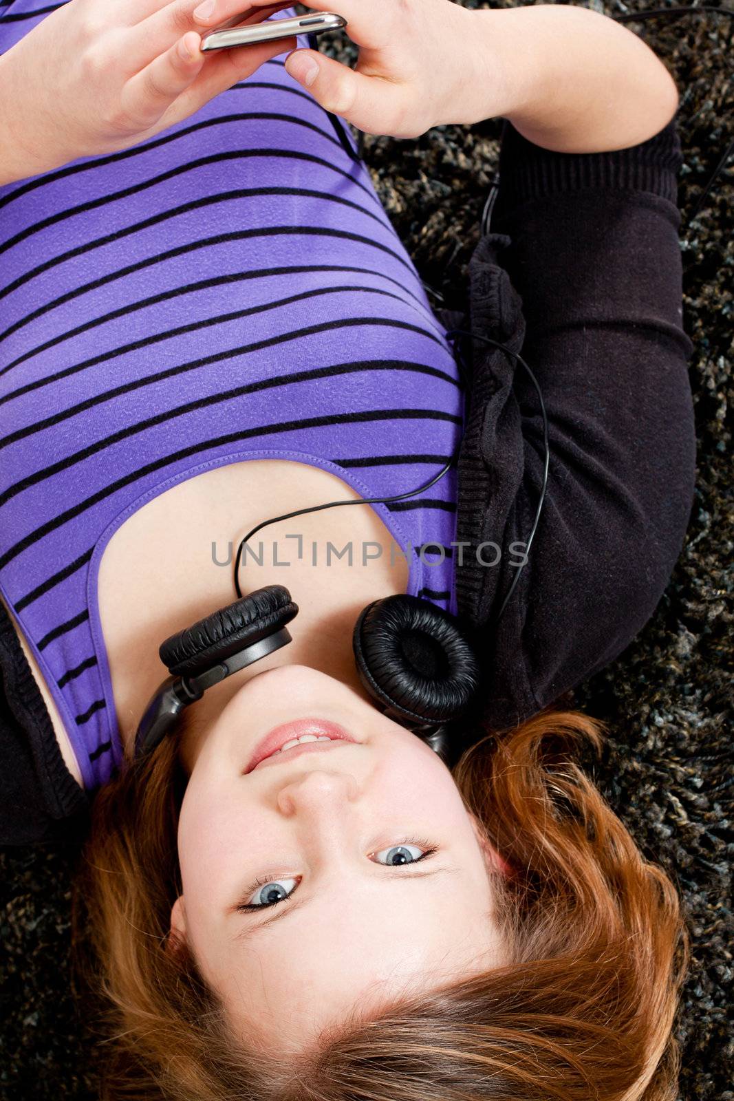 young smiling teenager girl at home with mp3 player and earphones listening to music