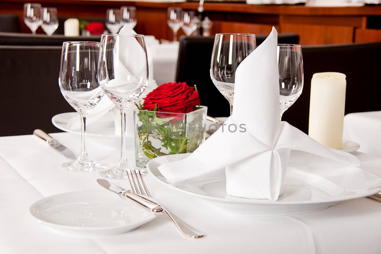 tables in restaurant with white tablecloth and elegant dish and silverwear