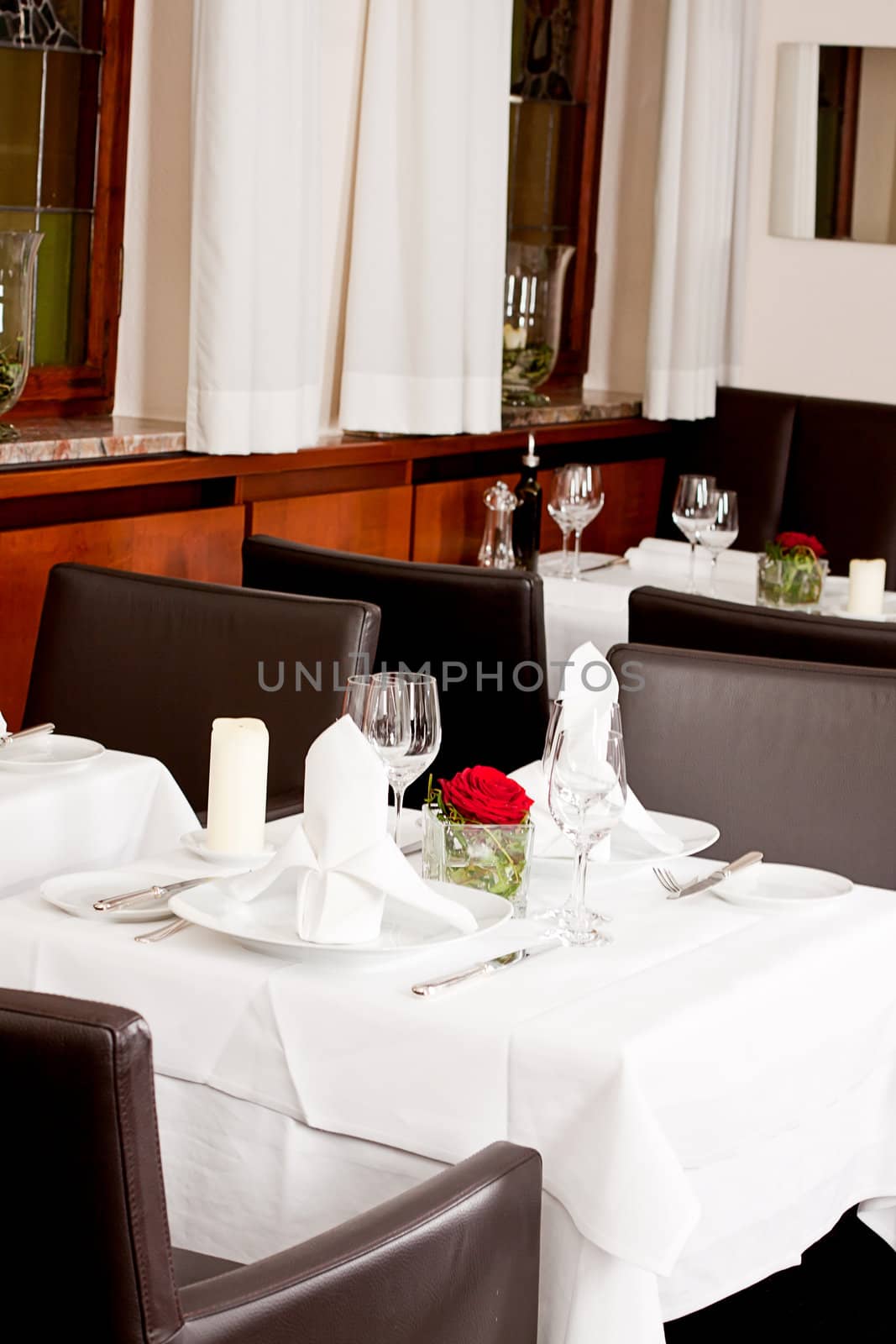 tables in restaurant with white tablecloth and elegant dish and silverwear