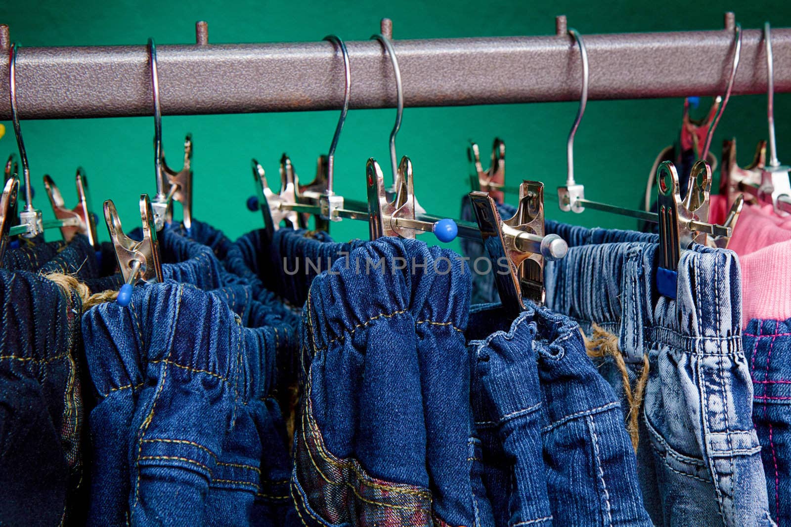a lot of bright children's clothing on a hanger in the store