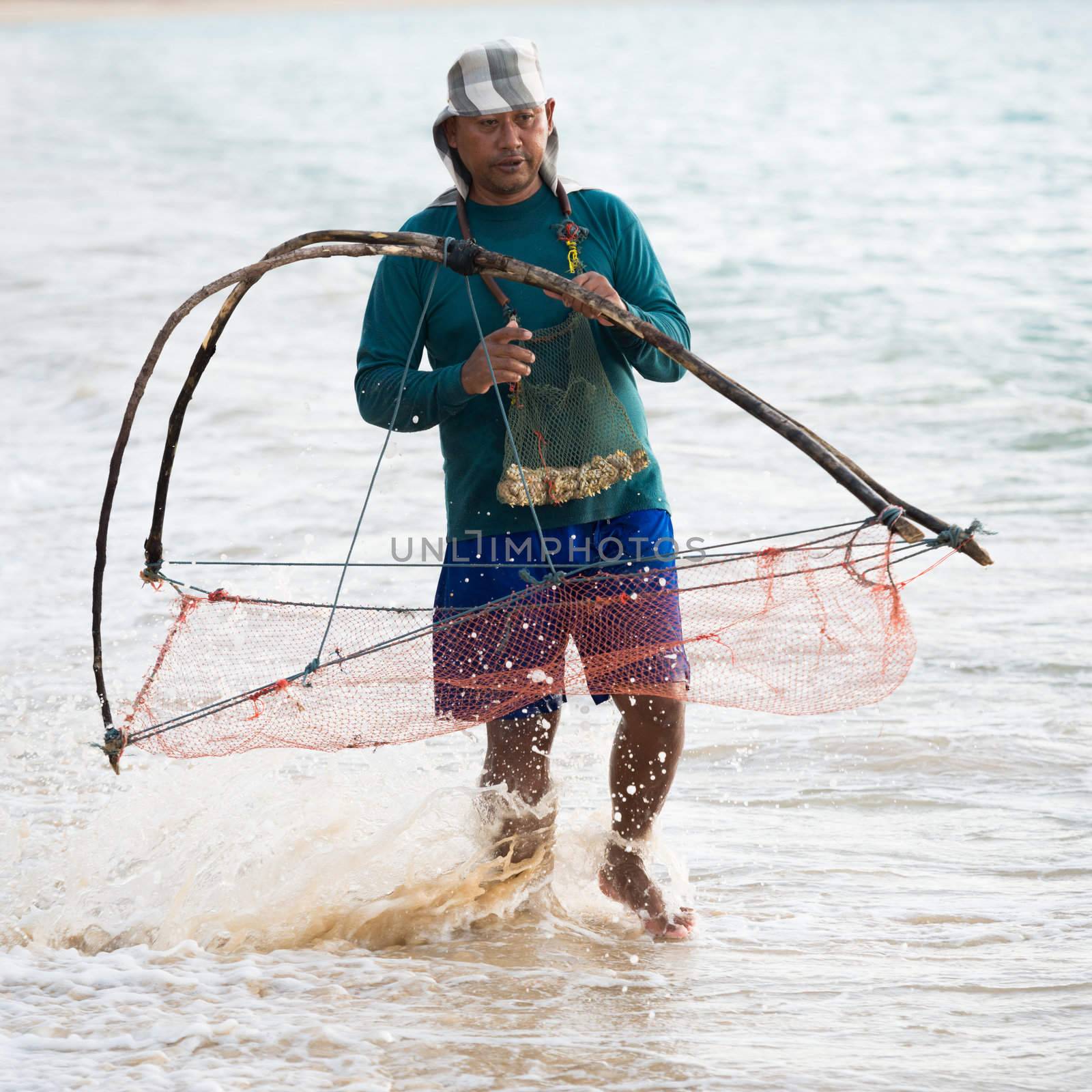PHUKET, THAILAND - FEB 15: Native local man nets small crustaceous in the sea on Feb 28, 2013 in Phuket, Thailand. Fishing and nets are popular among Thailanders 