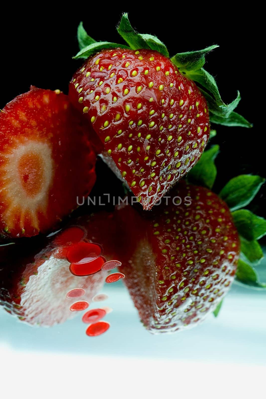 a sweet strawberry over a mirror
