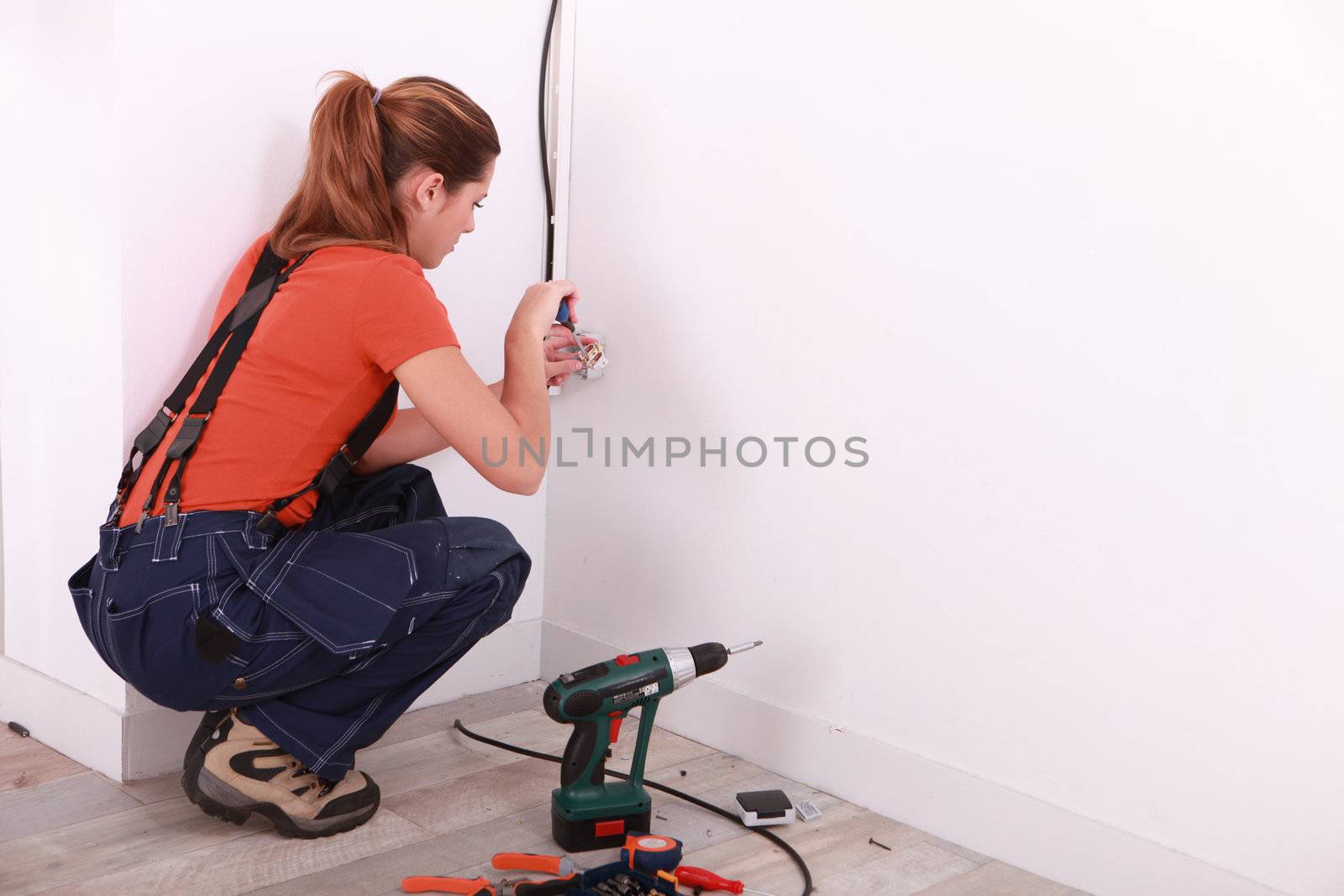 young woman installing electricity in a house