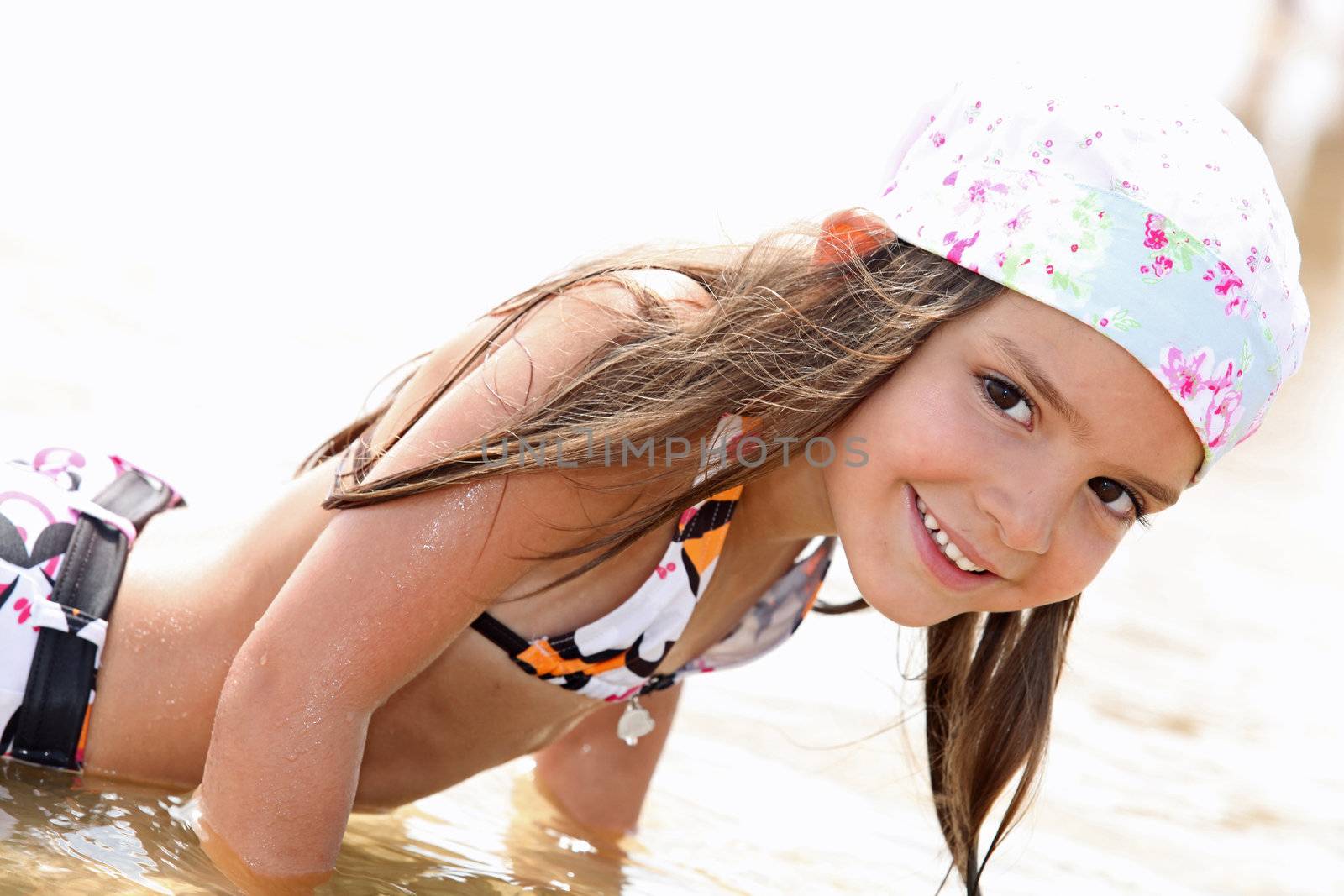 Cute little girl bathing in the sea by phovoir