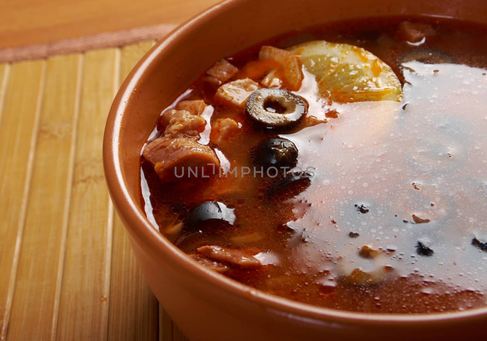 Solyanka on the plate.Solyanka, Russian soup with beef,sausage,chicken and lemon, olives