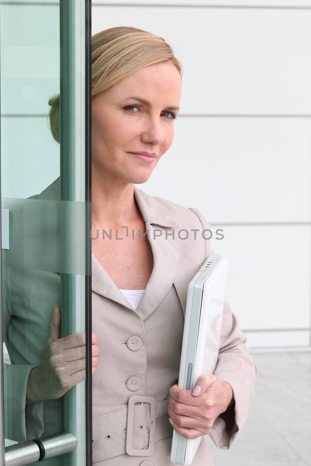 Blonde woman with a laptop in her arms