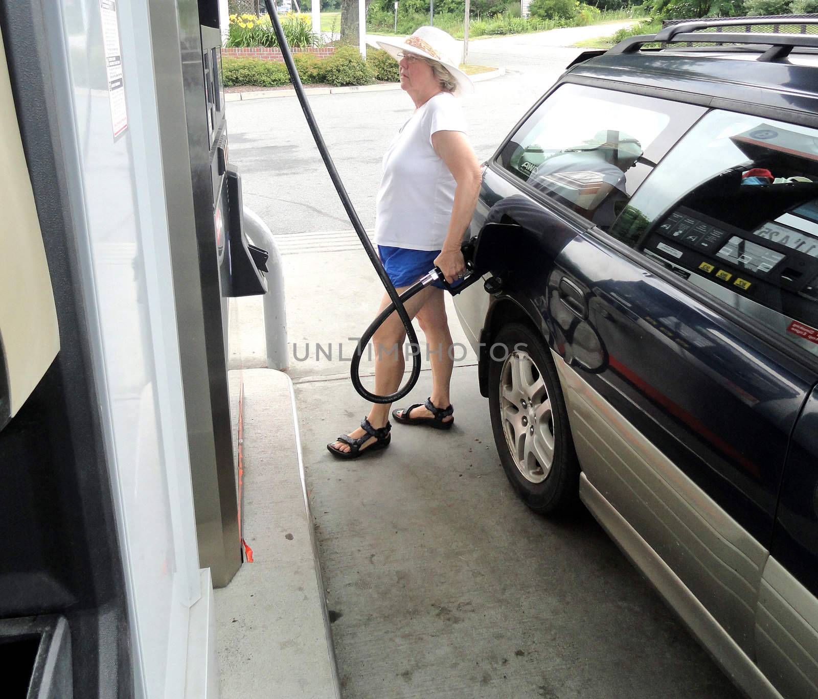 Female getting petrol at a service station.