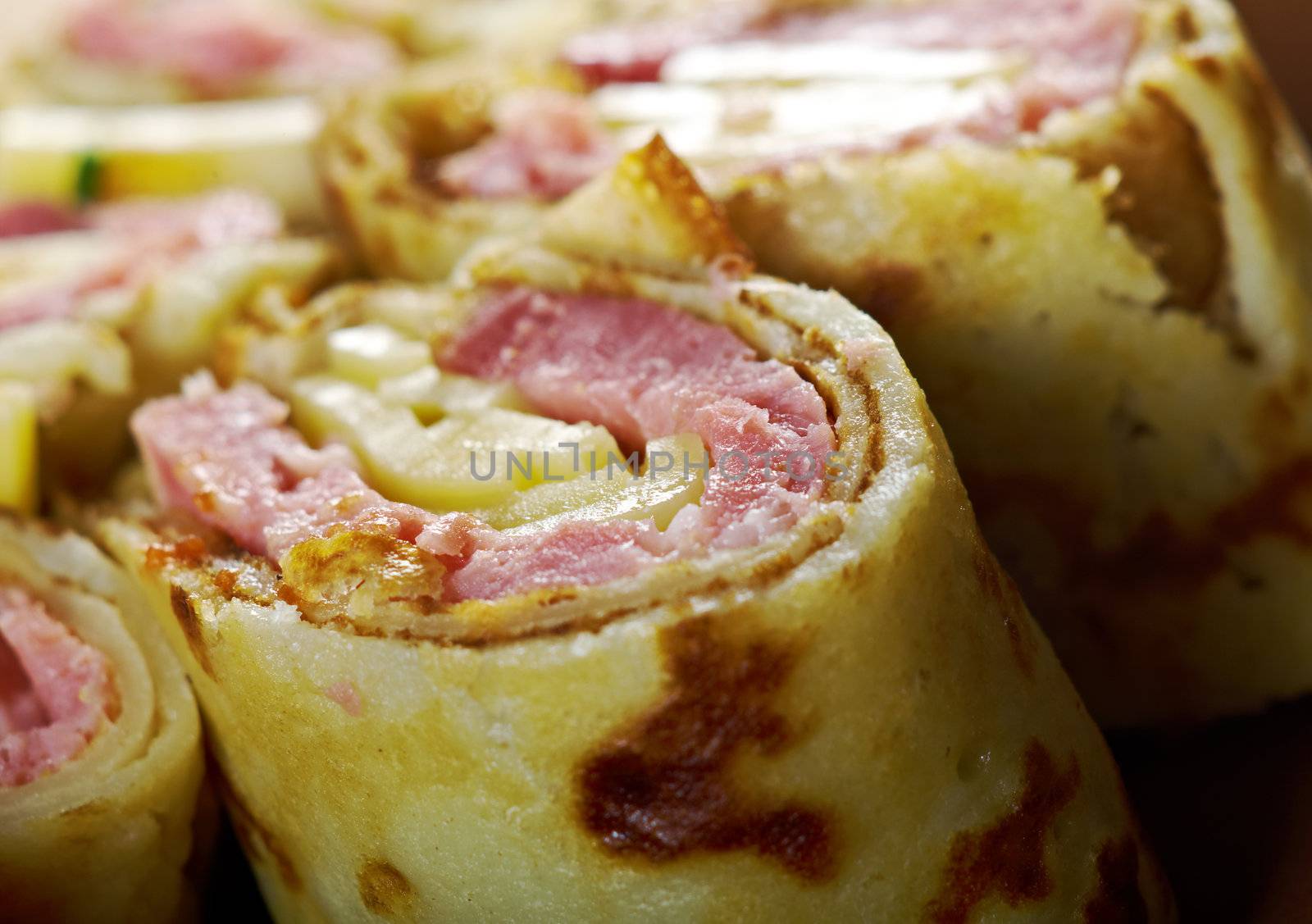 rolled pancakes stuffed ham and cheese. Shallow depth-of-field.