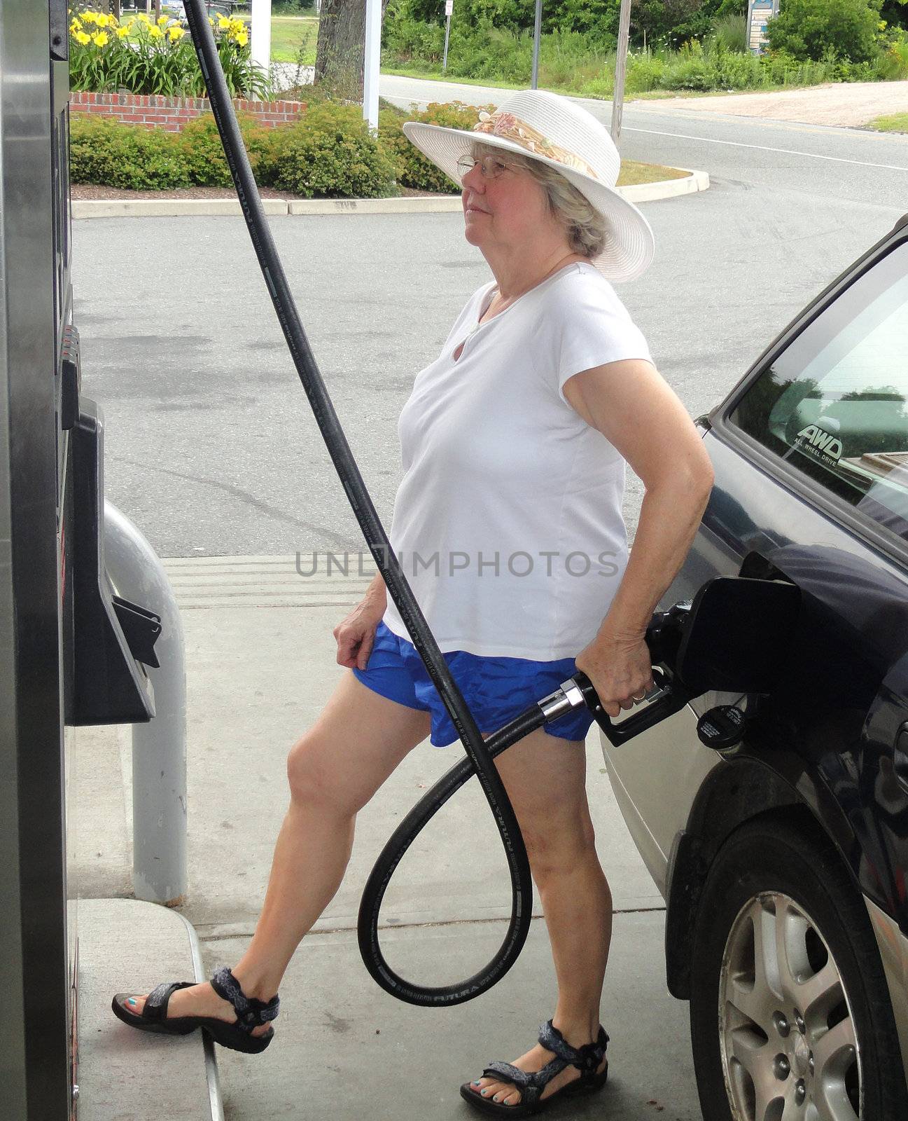 Female getting petrol at a service station.