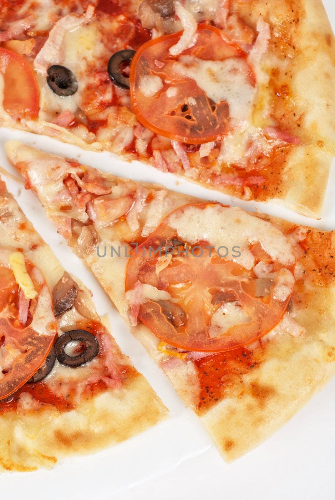 meat pizza closeup with carbonado ham, tomato, olive and mozzarella cheese