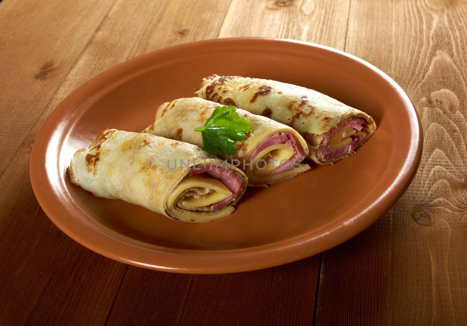 rolled pancakes stuffed ham and cheese. Shallow depth-of-field.
